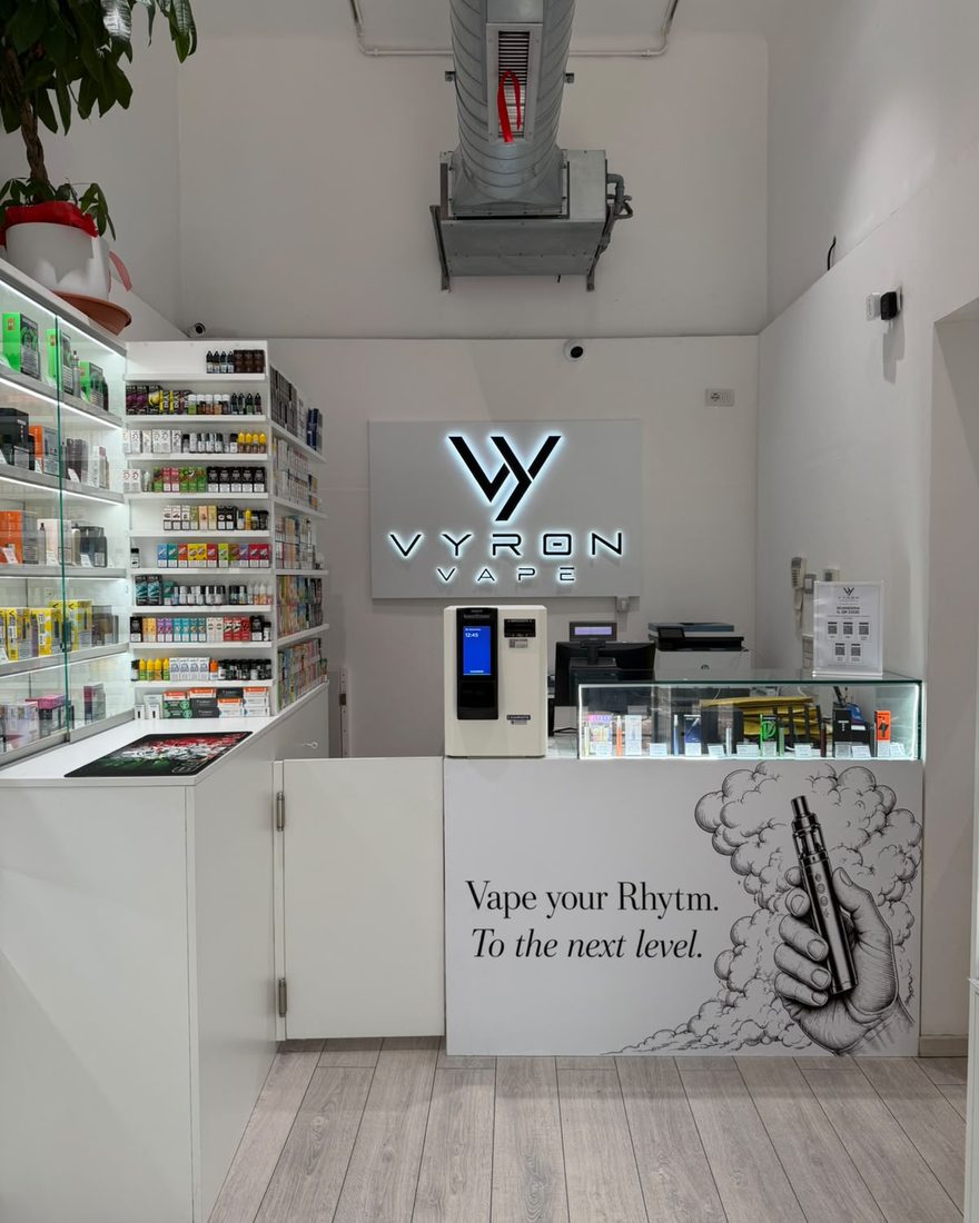 Il bancone di Vyron Vape con l'insegna luminosa e il pannello Vape your Rhythm